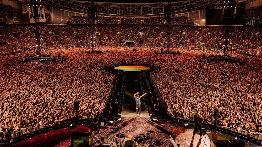 A packed stadium crowd at a major live concert, the captive audience at the centre of the festival economy